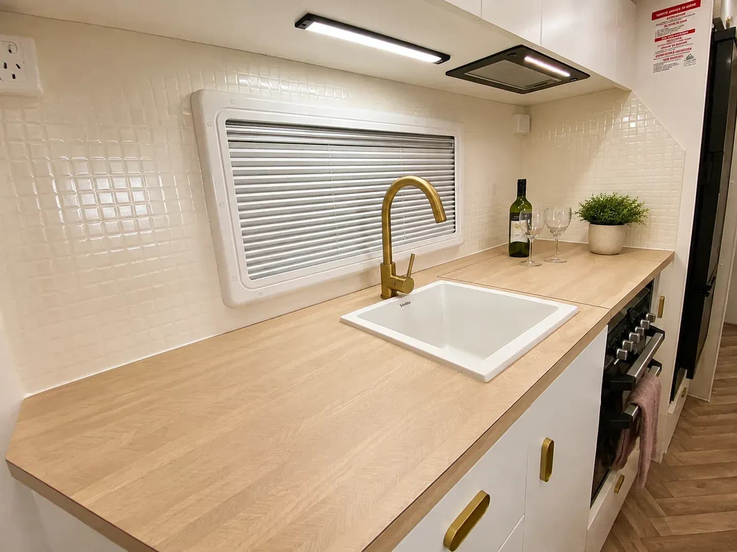 Galley and dinette — gold gooseneck mixer and white sink