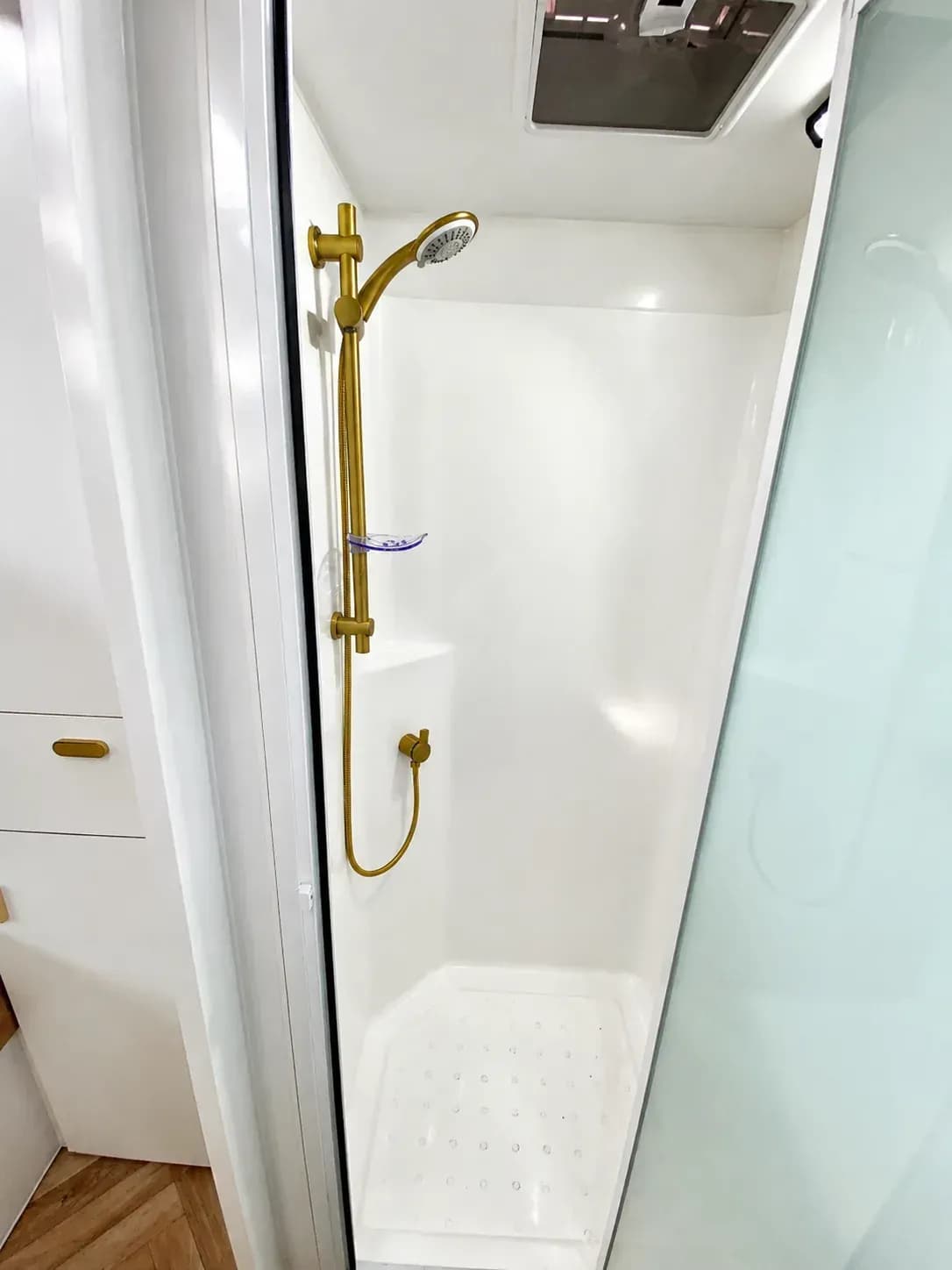 Gold square-spout mixer over the white kitchen sink